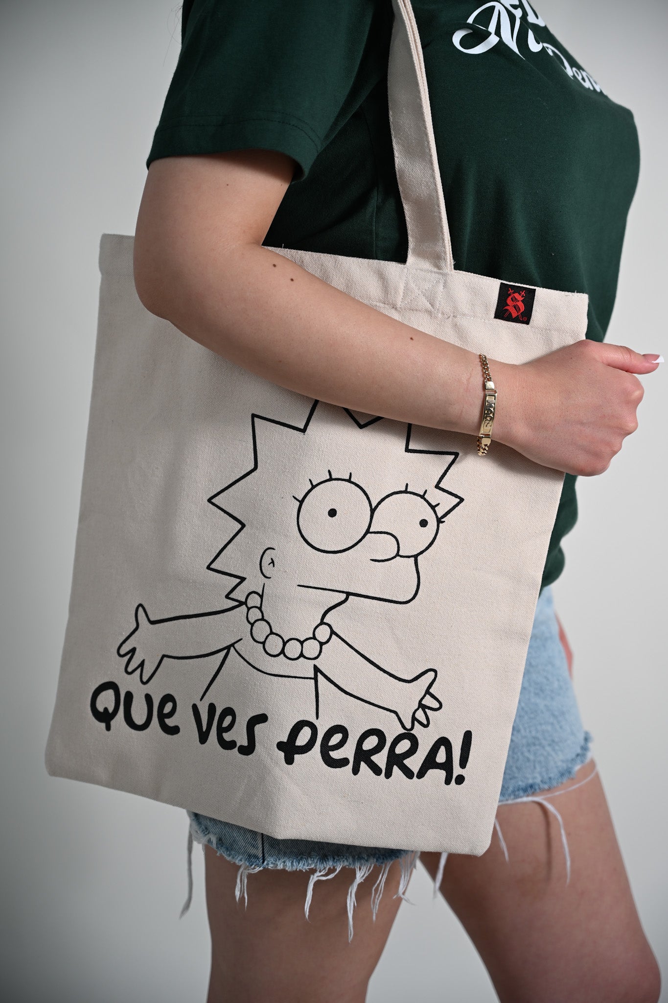 Person holding a tote bag with a cartoon character and text