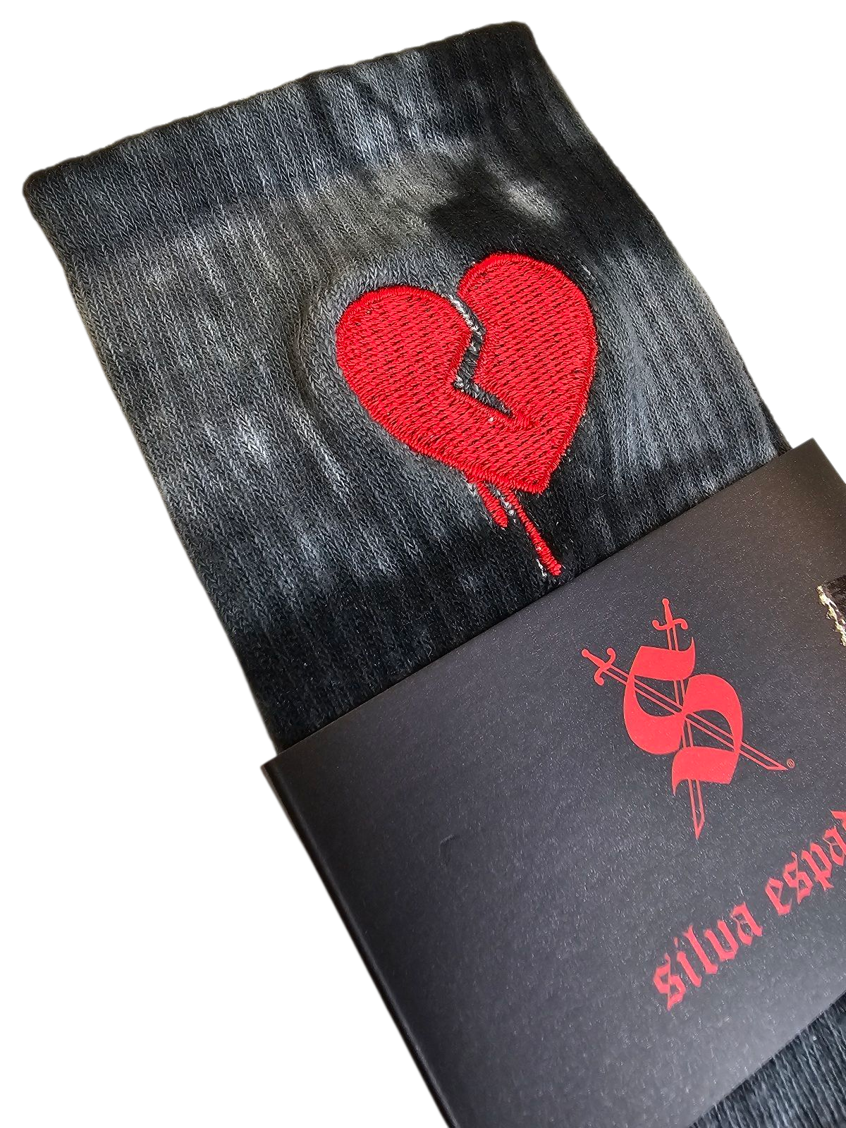 Black tie-dye socks with a red embroidered  broken heart design on a white background