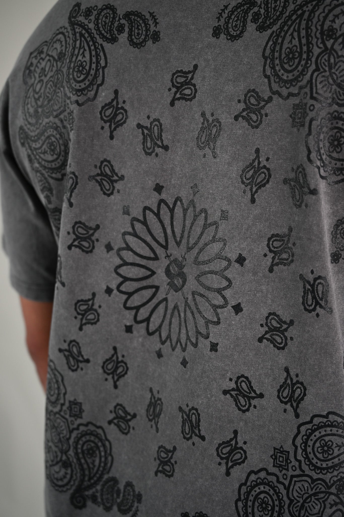 Gray t-shirt with black paisley bandana pattern on a plain background by Silva Espadas