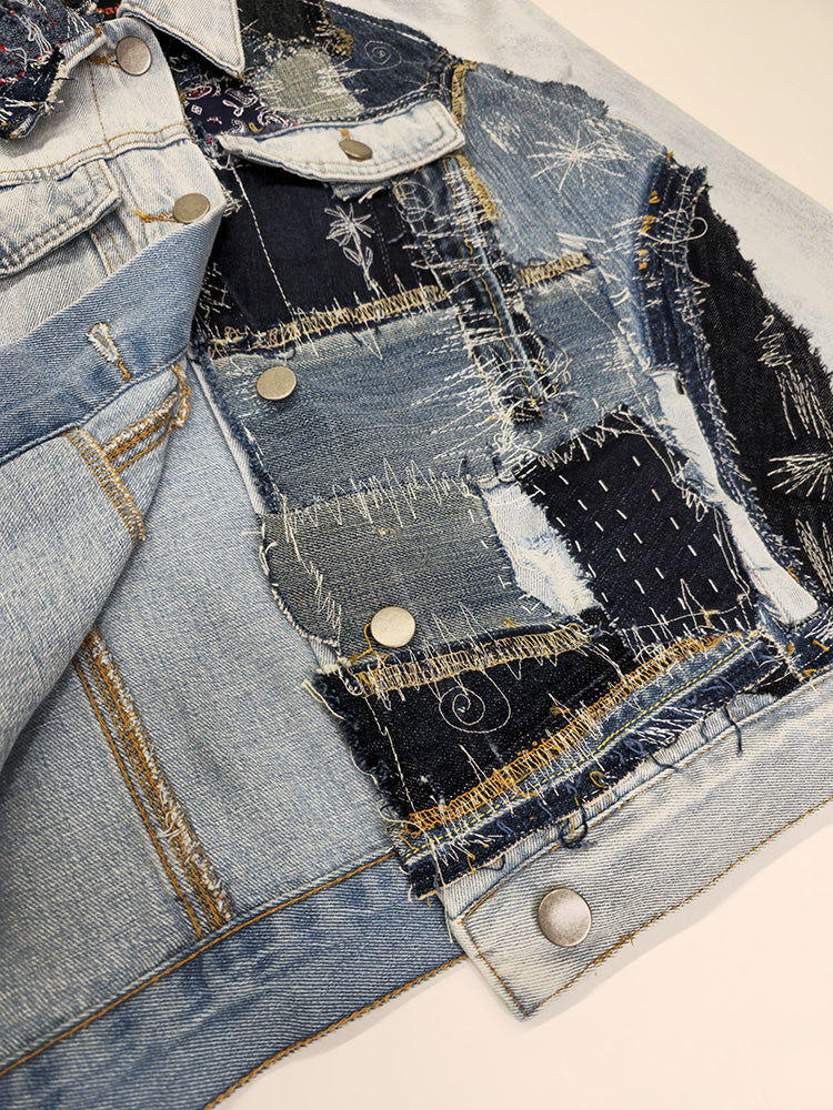 Close-up of repurposed denim jacket showing stitched patch panels in various textures and indigo wash tones