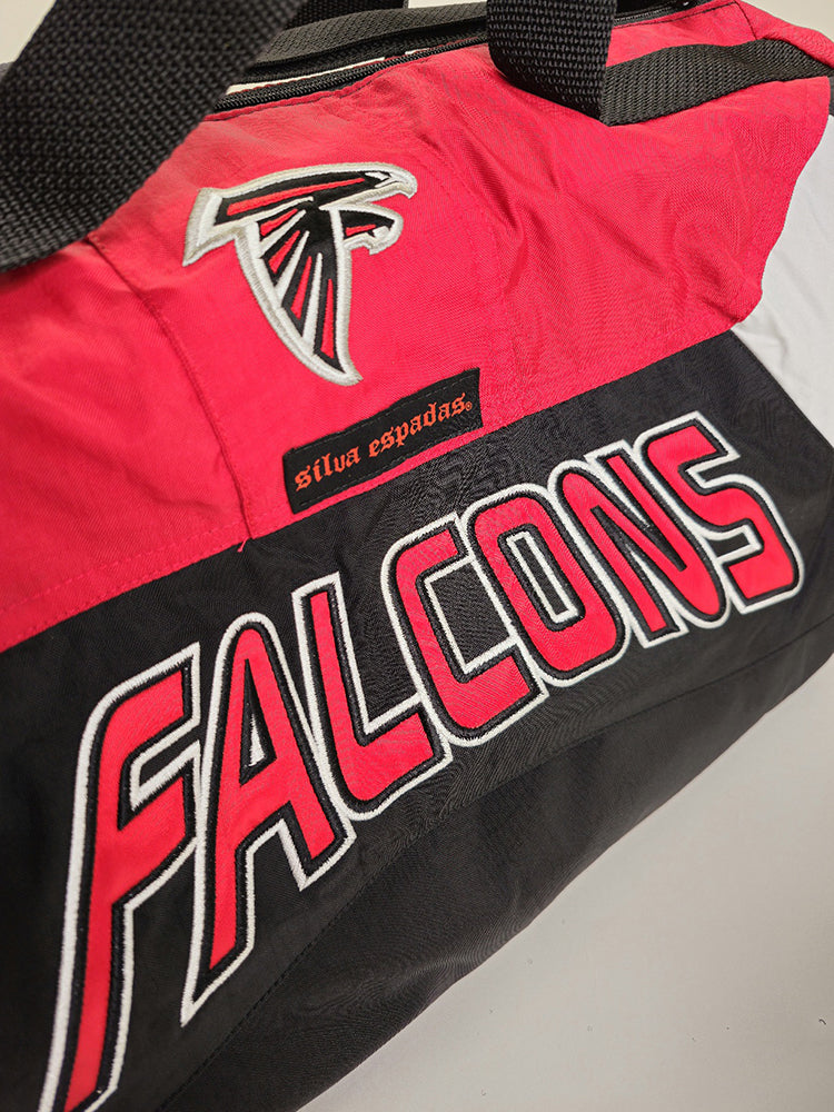 Detail view of a  handmade duffle bag with the Atlanta Falcons logo made from a starter jacket
