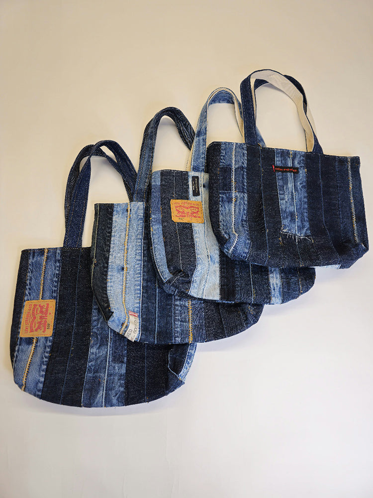 Four handmade disstressed denim tote bags on white background