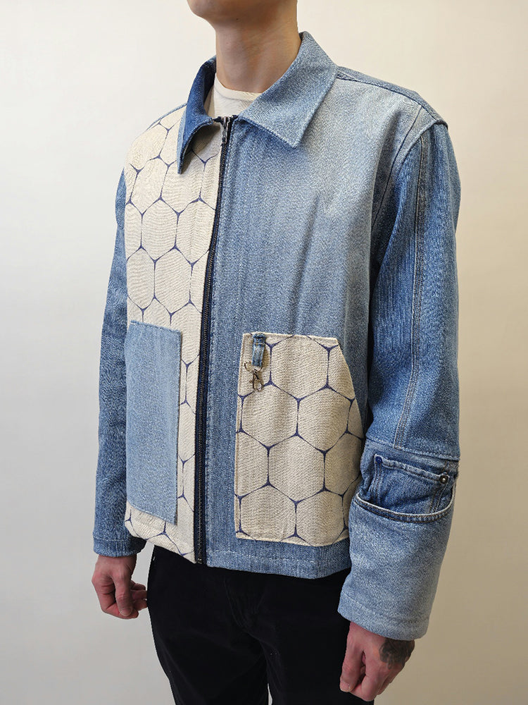 Model wearing A denim honeycomb jacket with two slanted opening pockets on front panels and a boxy fit. The jacket features a mix of solid denim and honeycomb patterned fabrics.