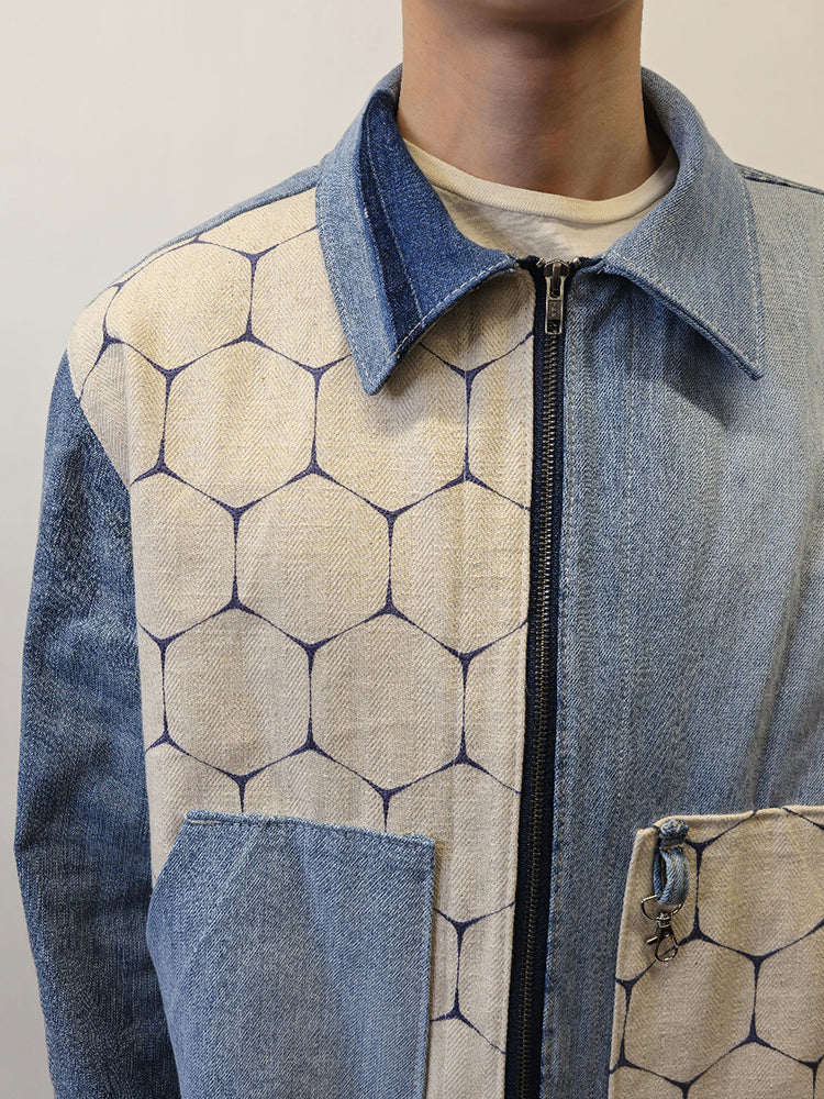 A denim honeycomb jacket with two slanted opening pockets on front panels and a boxy fit. The jacket features a mix of solid denim and honeycomb patterned fabrics.