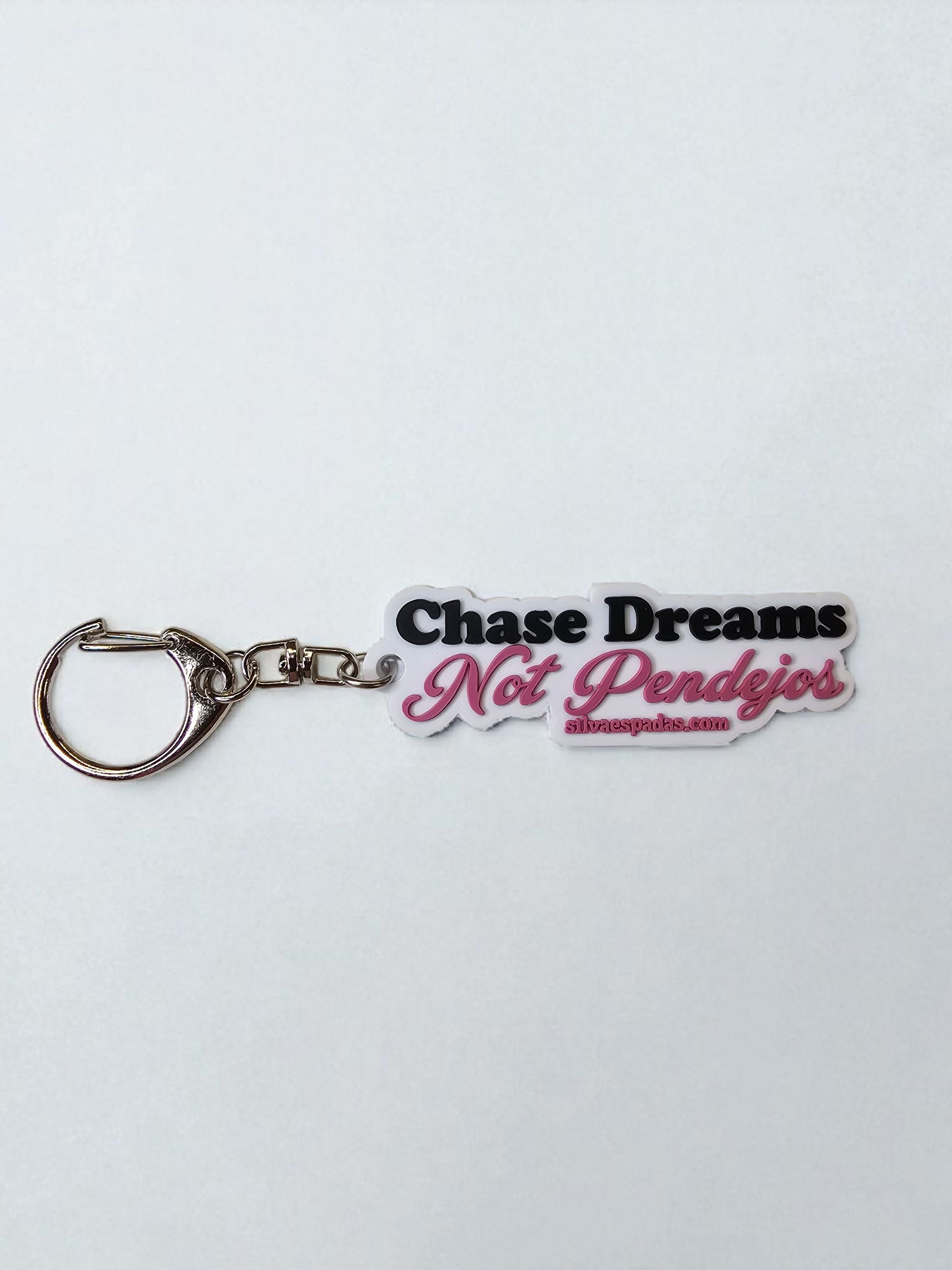 Keychain with 'Chase Dreams Not Pendejos' text on a white background