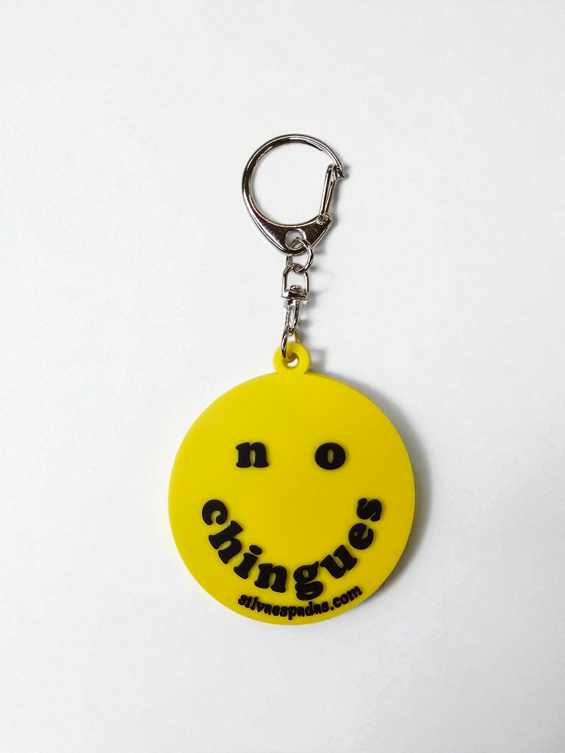 Yellow keychain with 'no chingues' text on a white background