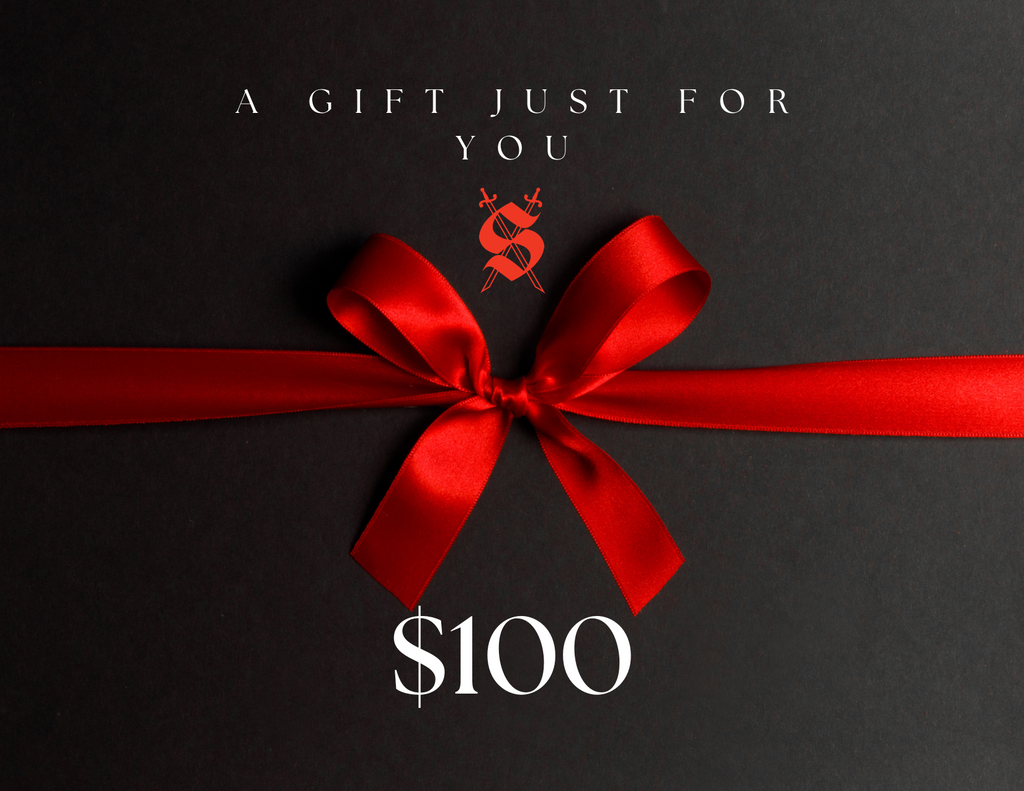 A red ribbon gift card with a silver embossed logo and text that reads 'A Gift Just For You' from Silva Espadas, denomination $100.