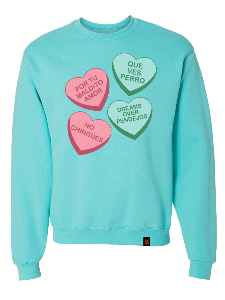 A blue crewneck sweater with Maldito Amor graphic of multicolored heart-shaped candies on the front.