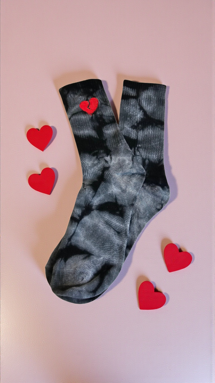 Gray tie-dye socks with red hearts on a pink background