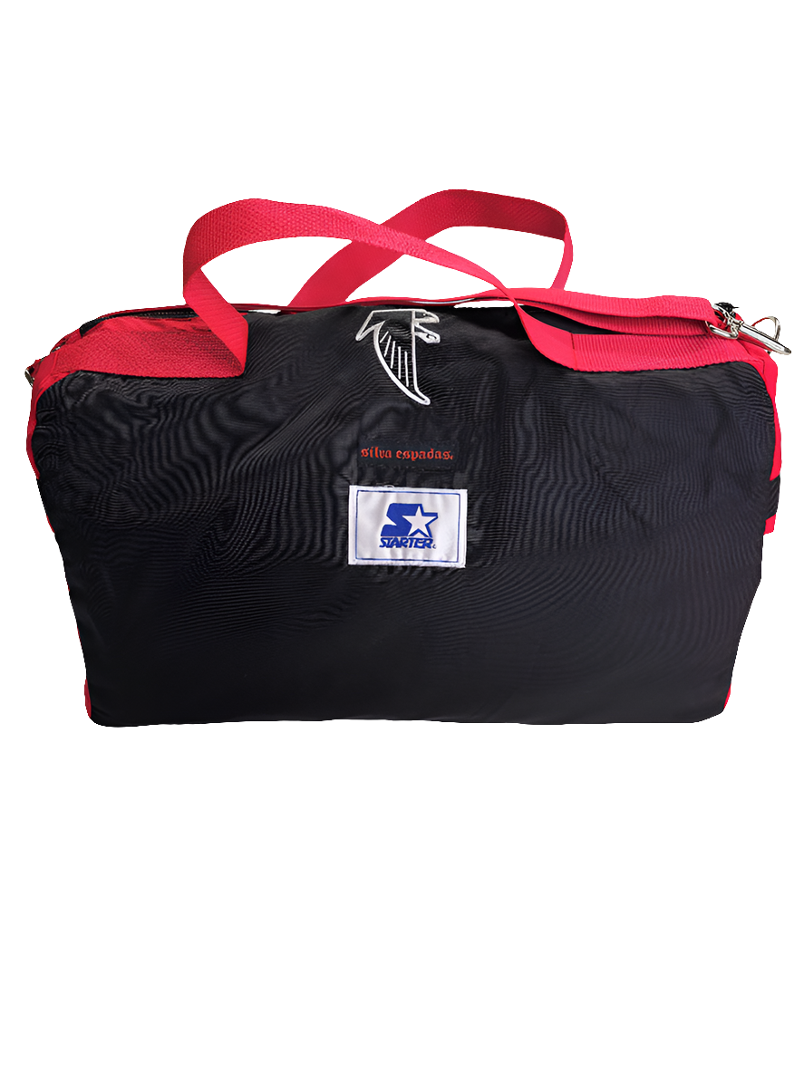 A custom handmade duffle bag made from a Atlanta Falcons Starter jacket and heavy canvas, predominantly black with red accents and the Falcons and Starter brand logo.