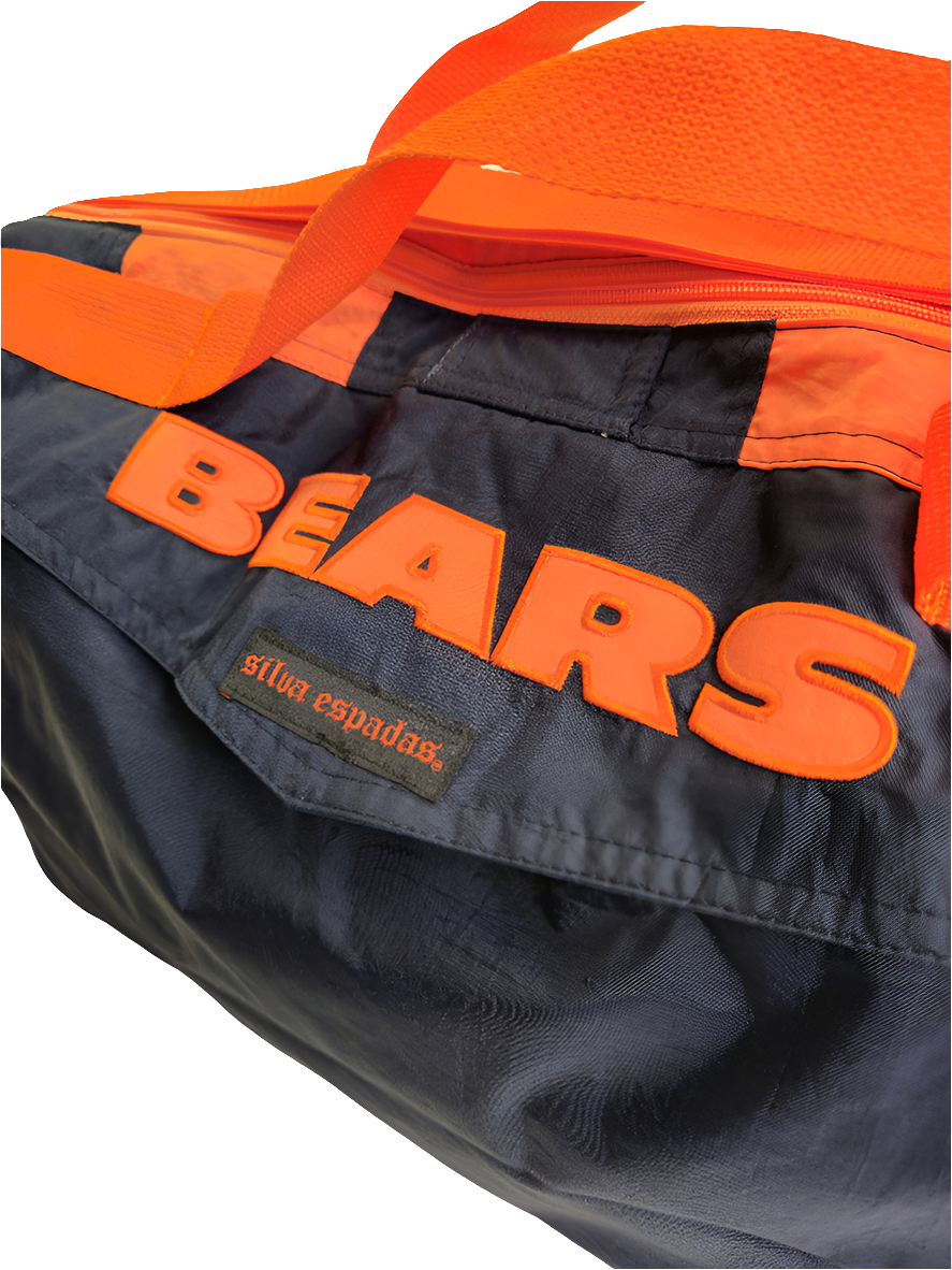 A custom handmade duffle bag made from a Chicago Bears Starter jacket and heavy canvas, predominantly navy blue with orange accents and the Bears logo