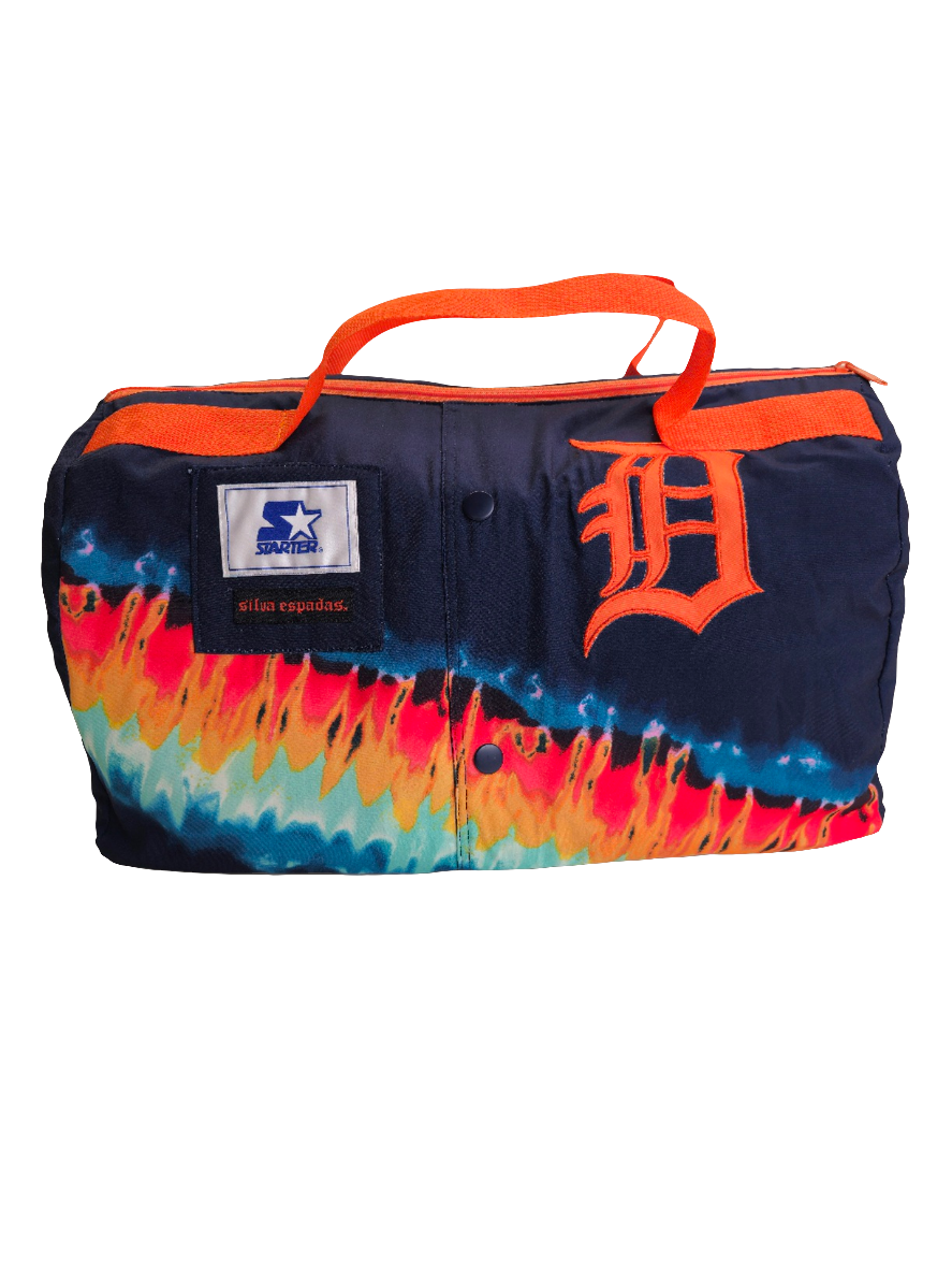 A multicolored handmade duffle bag with Detroit Tigers branding and an orange strap.