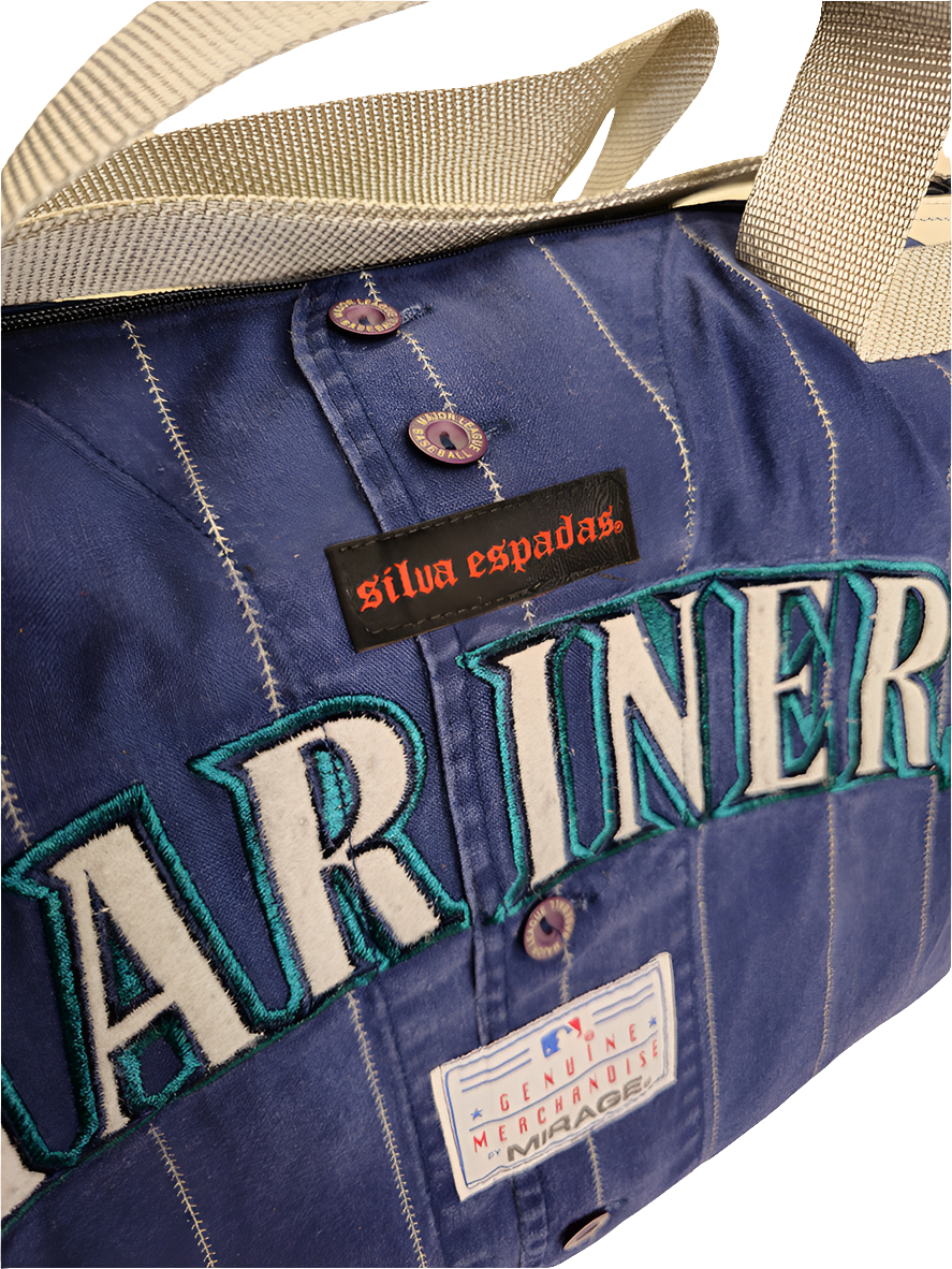 A custom handmade duffle bag made from a Seattle Mariners jersey and heavy canvas, predominantly navy blue with the genuine merchendise logo