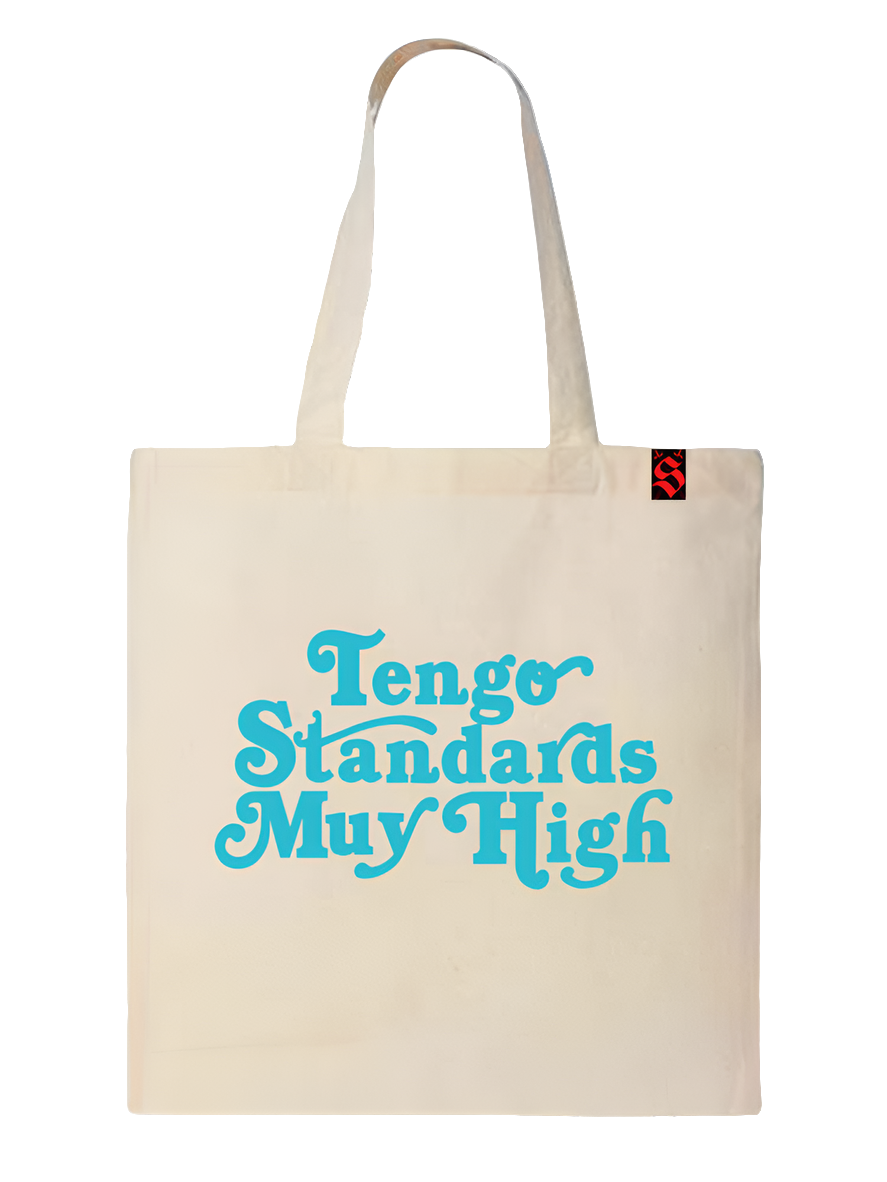 Natural color tote bag with the phrase "Tengo standards muy high" in blue printed on it