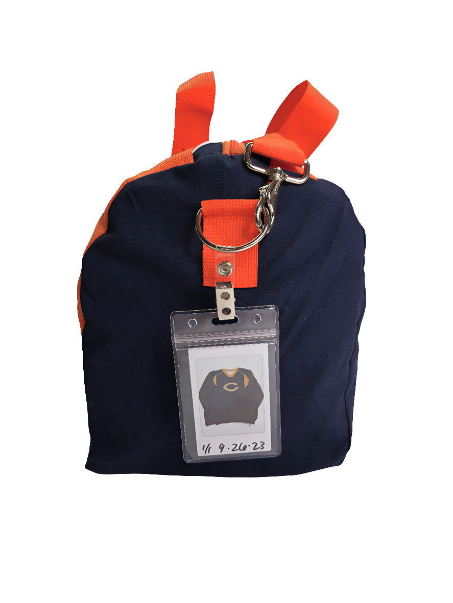A custom handmade duffle bag made from a Chicago Bears jacket and heavy canvas, predominantly blue with orange accents and the Bears C logo.