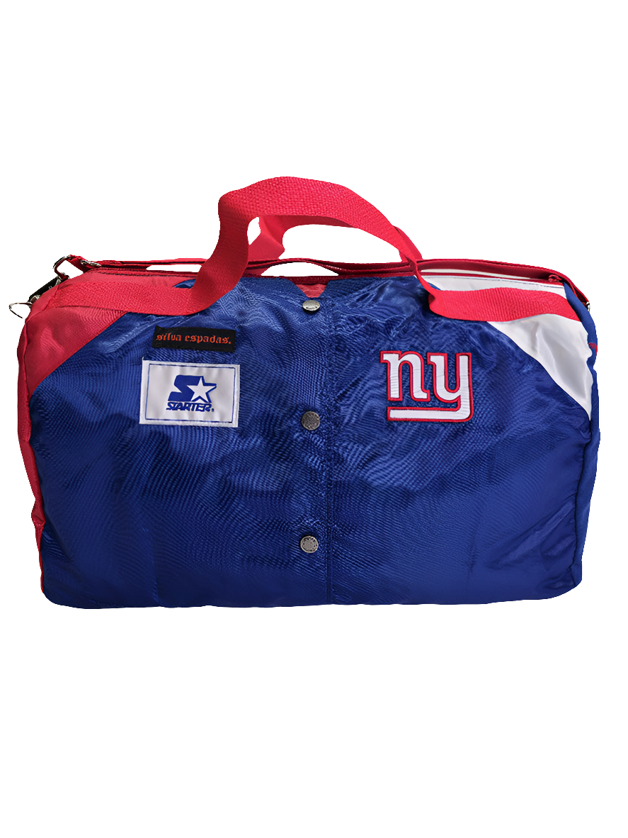 A custom handmade duffle bag made from a NY Giants Starter jacket and heavy canvas, predominantly blue with red and white accents and the NY Giants logo.