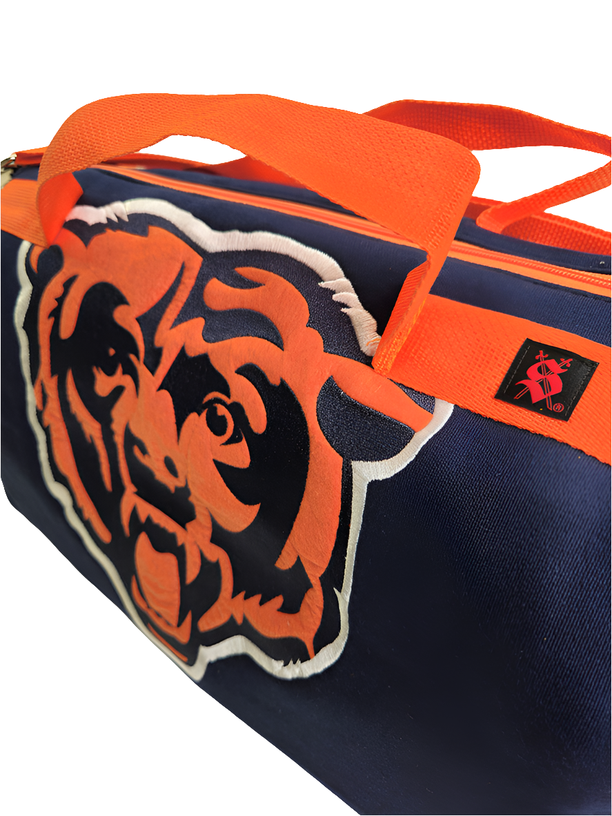 A custom handmade duffle bag made from a Chiago Bears Starter jacket and heavy canvas, predominantly navy blue with orange accents and the Bears logo