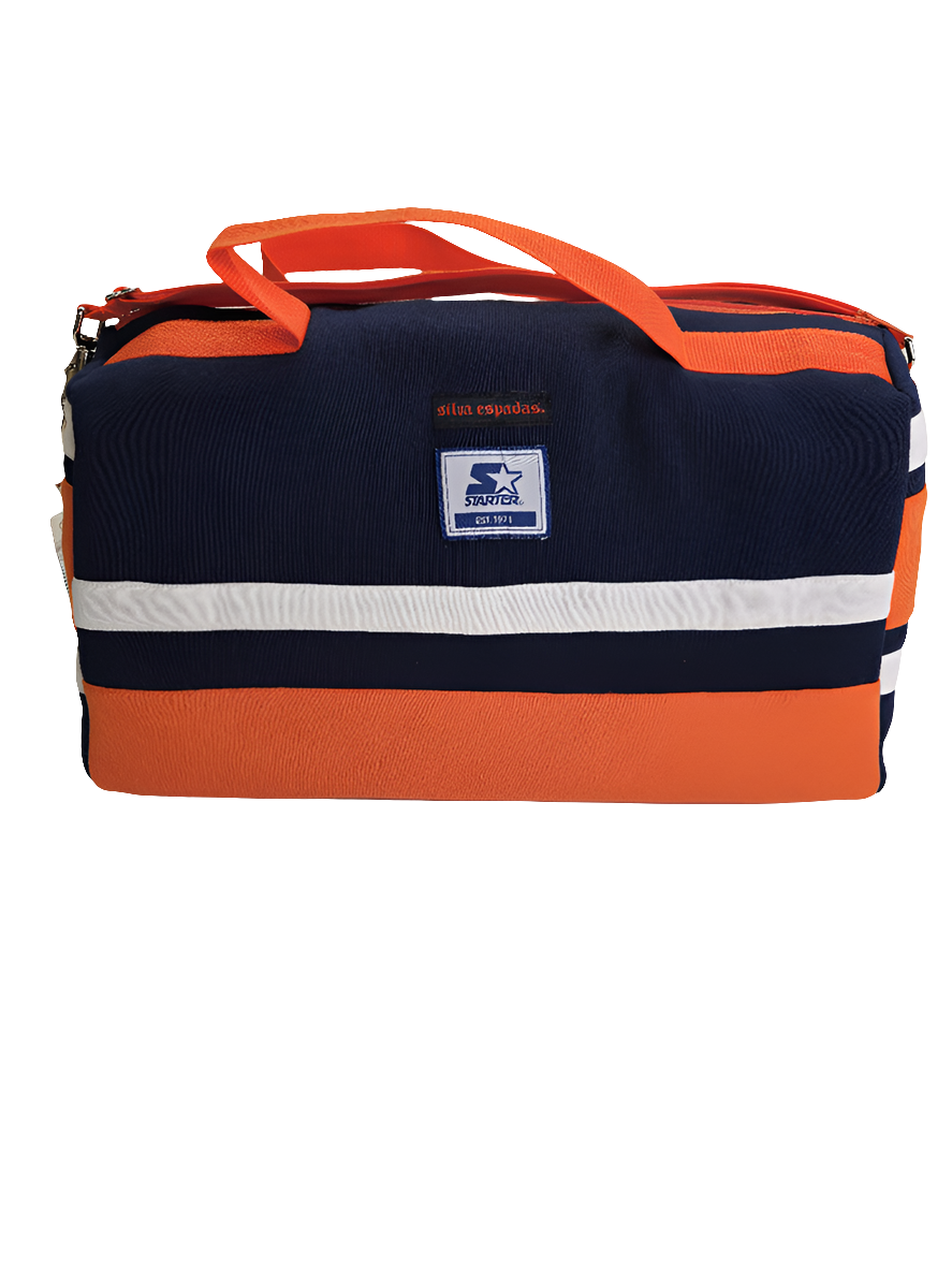 A custom handmade duffle bag made from a Chiago Bears Starter jacket and heavy canvas, predominantly navy blue with orange accents and the Starter brand logo