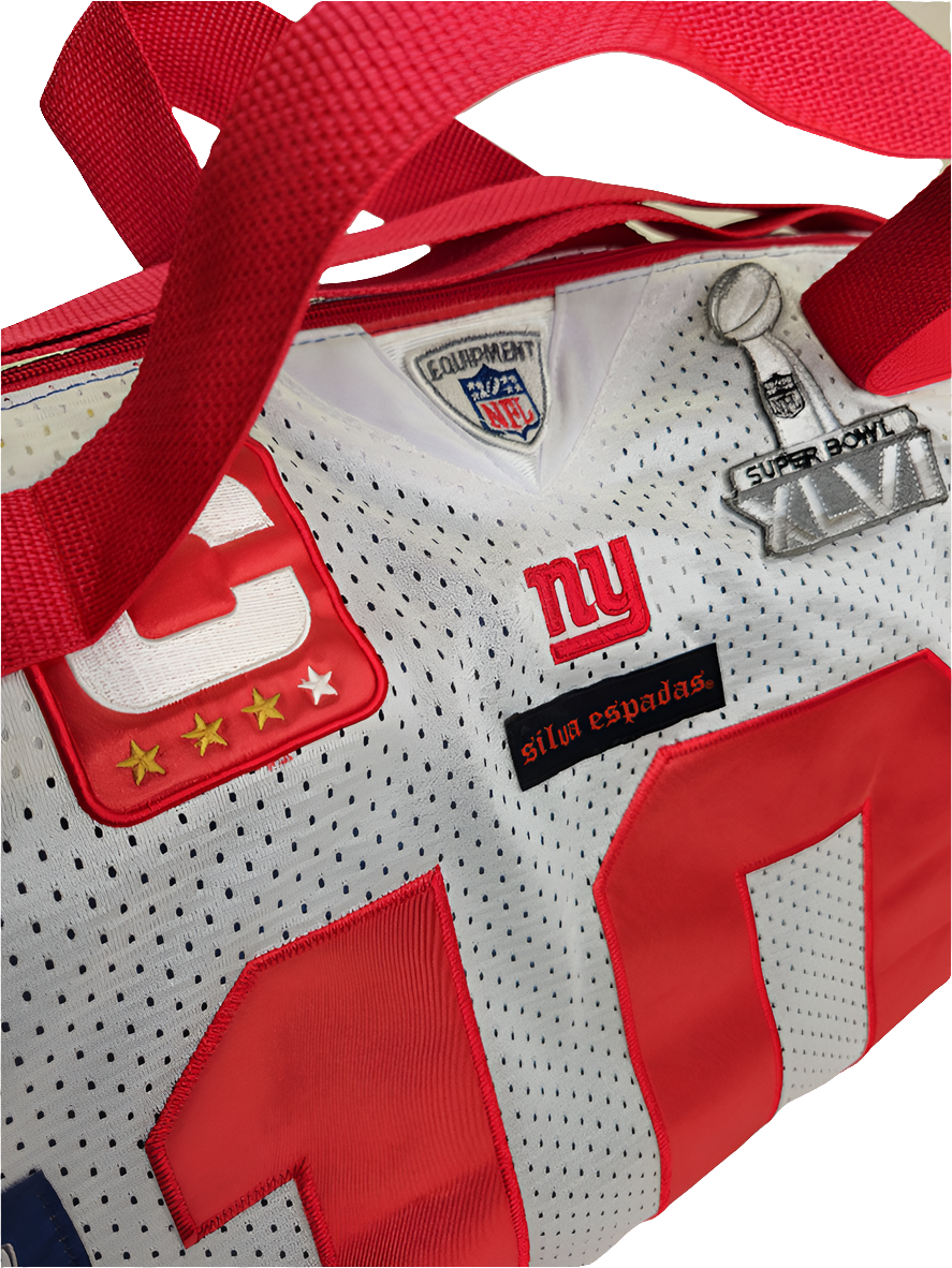 A custom handmade duffle bag made from a NY Giants Manning jersey and heavy canvas, predominantly white with red and accents and the NY Giants logo.