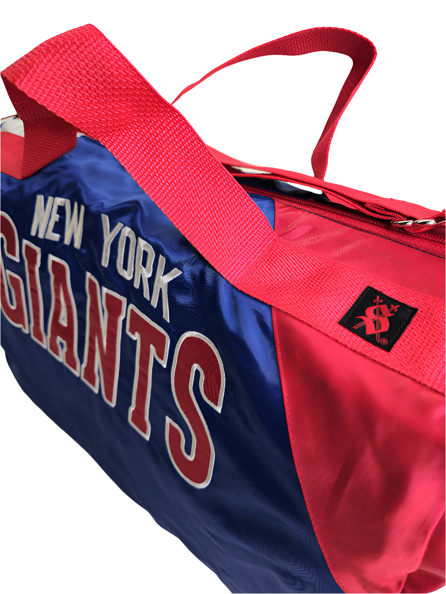 A custom handmade duffle bag made from a NY Giants Starter jacket and heavy canvas, predominantly blue with red and white accents and the NY Giants logo.