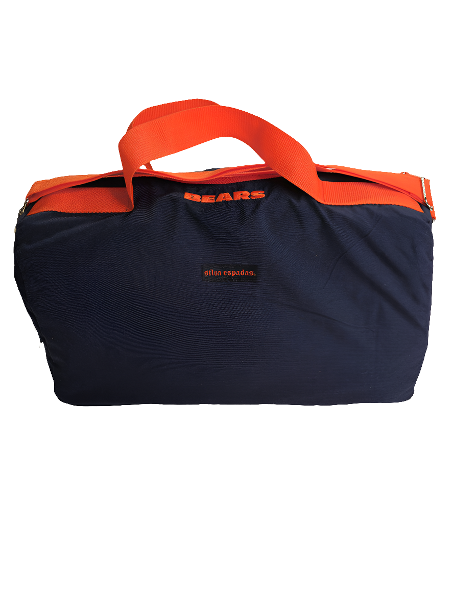 A custom handmade duffle bag made from a Chicago Bears jacket and heavy canvas, predominantly blue with orange accents and the Bears C logo.
