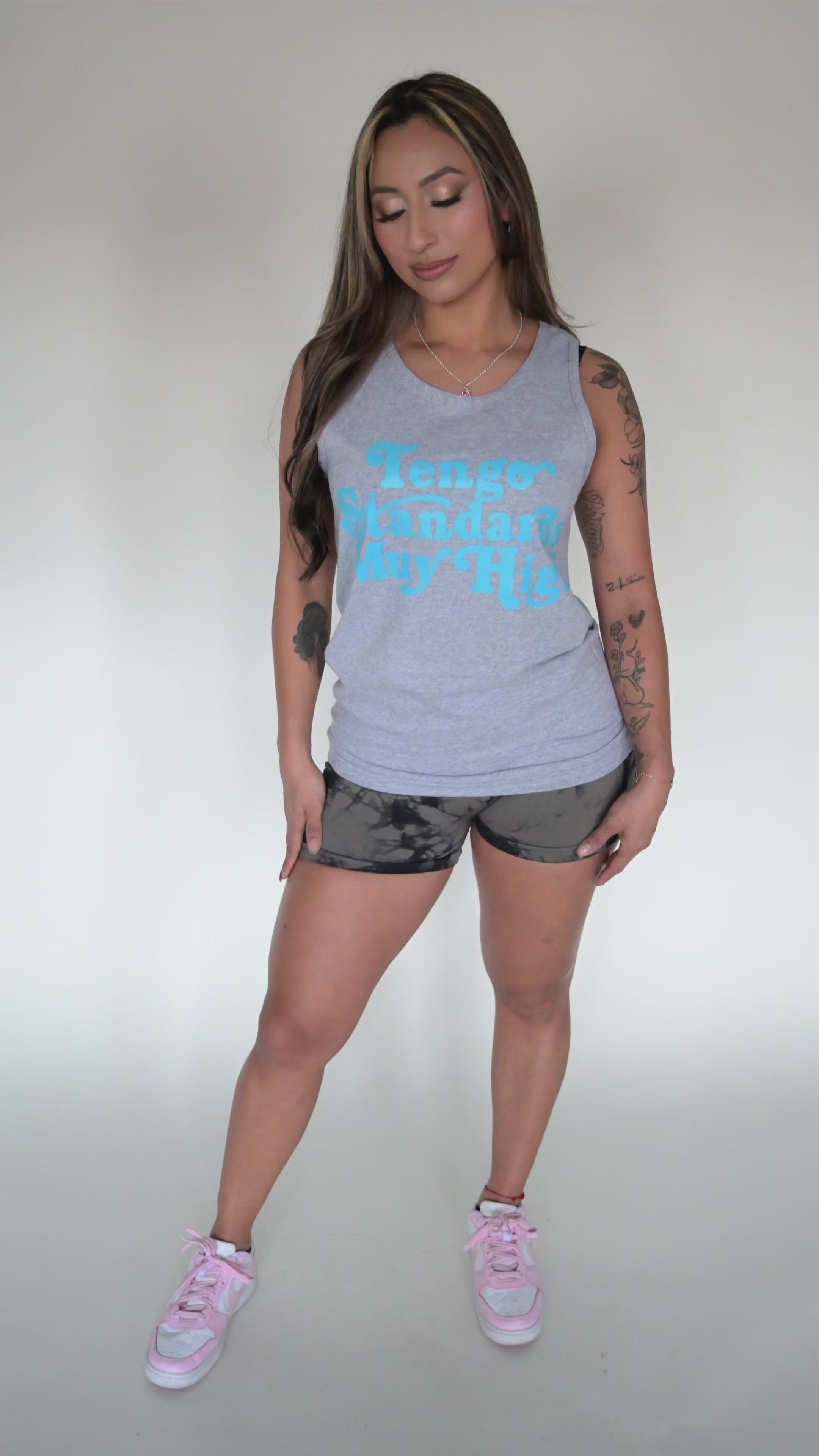 person modeling a gray tank top with graphic text on the front with white plaing background