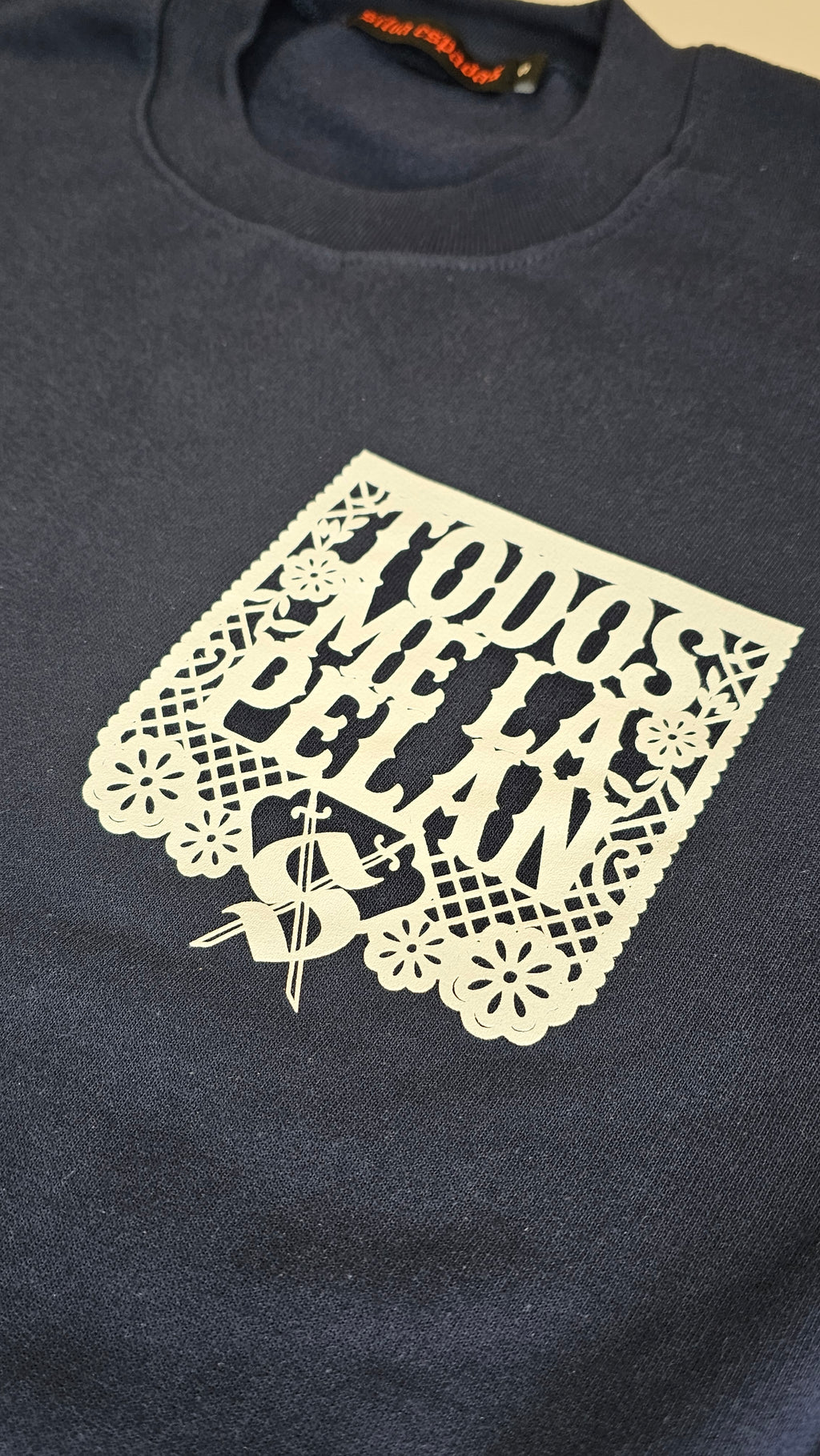 Navy sweater with a white lace design on a beige background