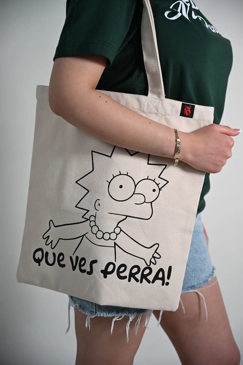Person holding a tote bag with a cartoon character and text