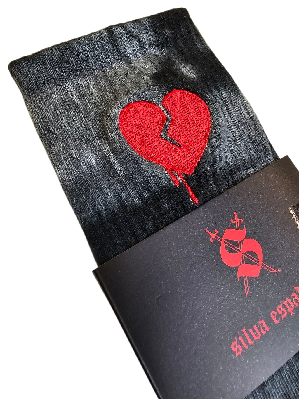 Black tie-dye socks with a red embroidered  broken heart design on a white background