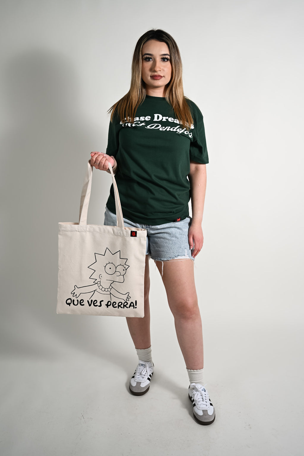 Person holding a tote bag with a graphic design on a plain background