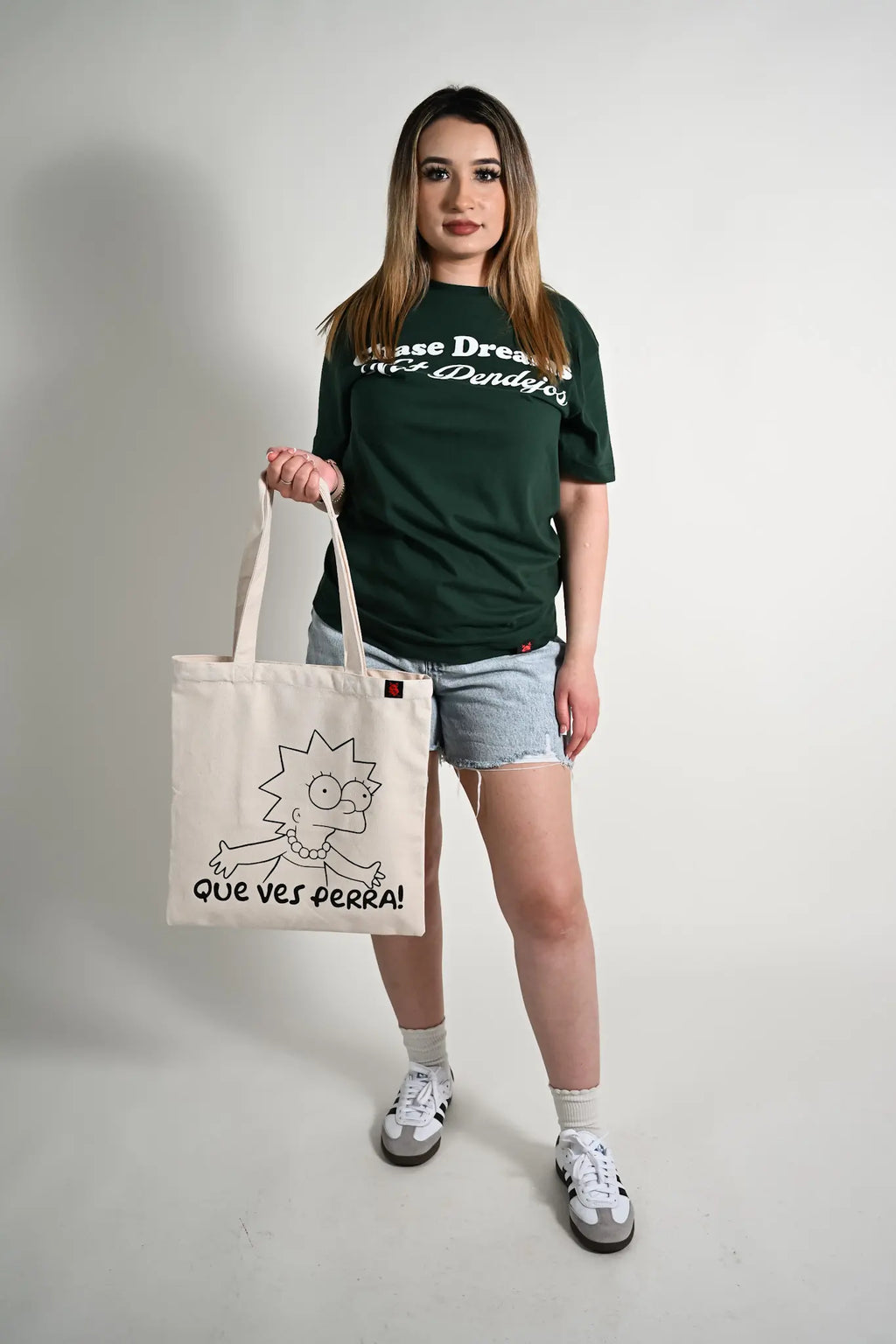 Person holding a tote bag with a cartoon character design on a plain background