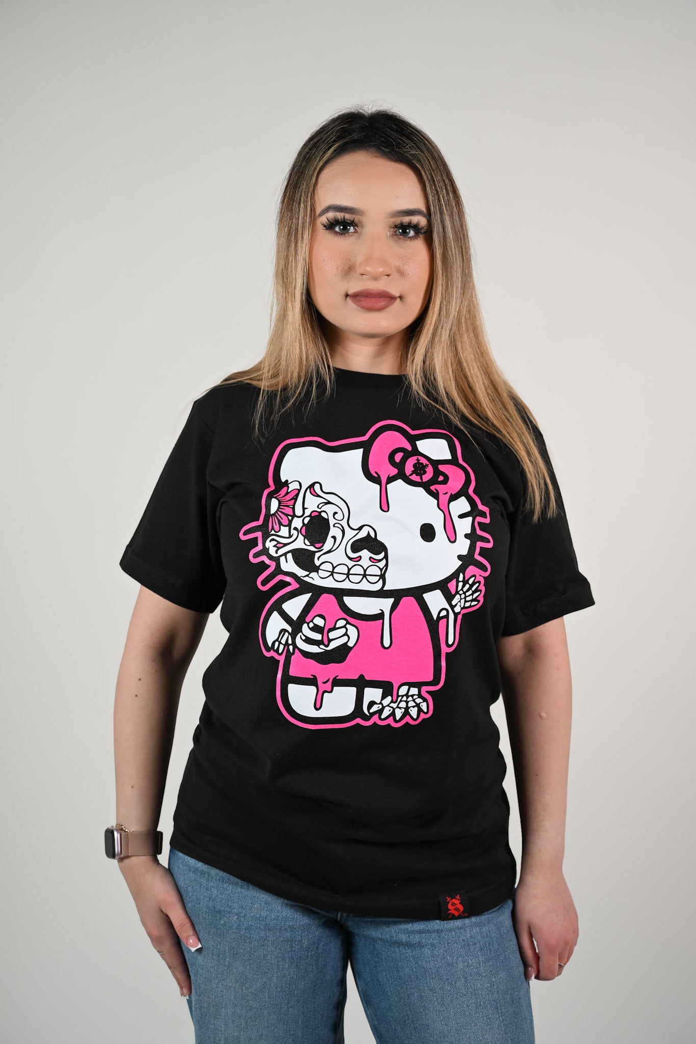 Person wearing a black unisex t-shirt with a graphic design of Hello Kitty day of the dead skull