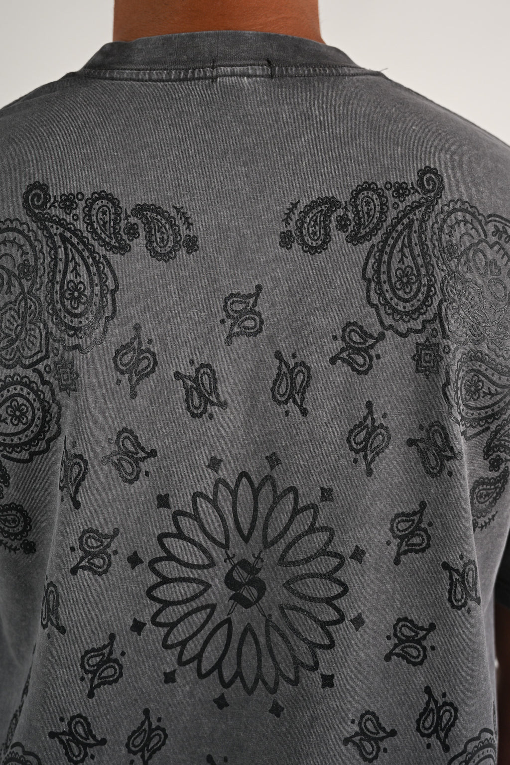 Gray shirt with black skull paisley patterns on a plain background