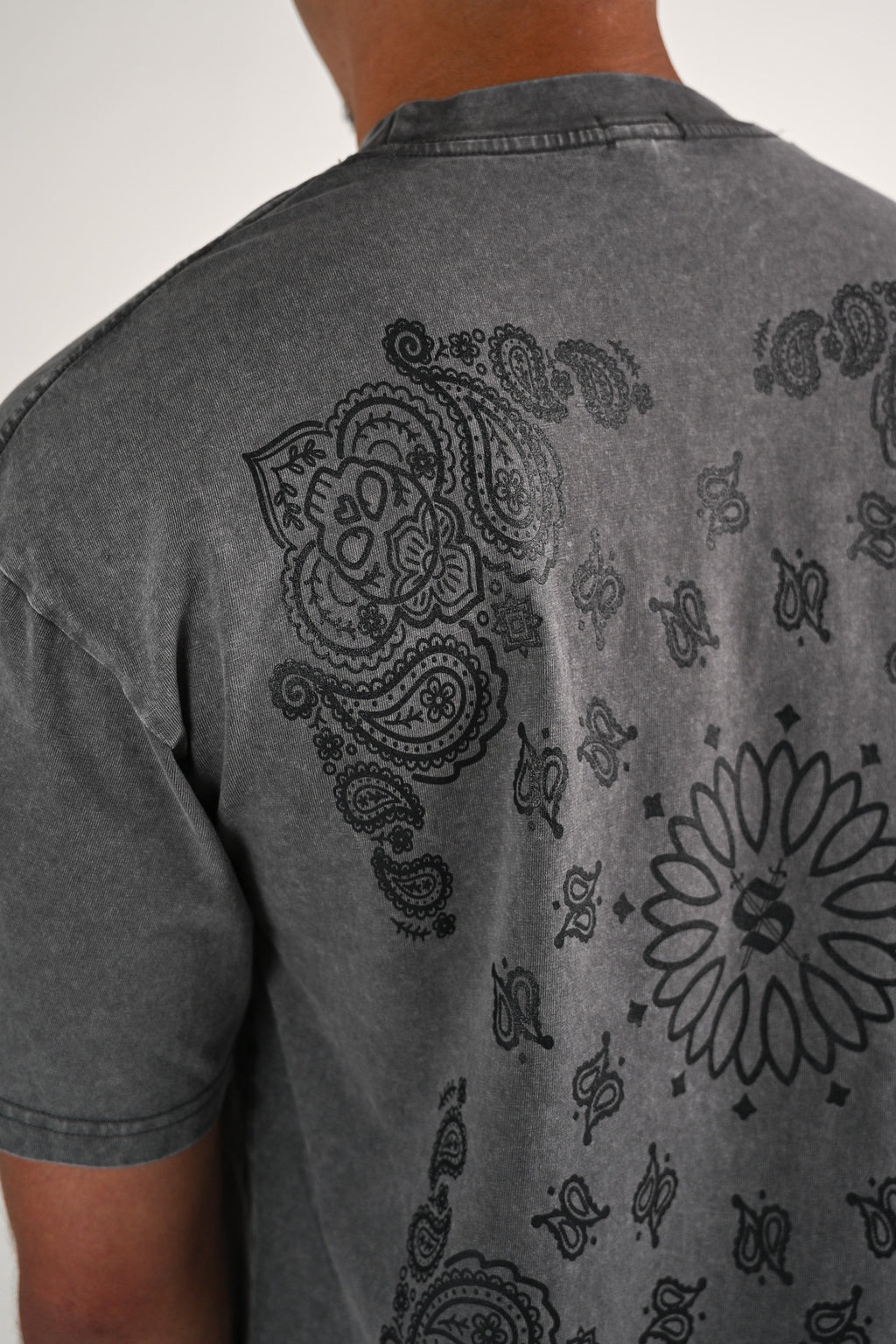 Close up of a gray acid wash t-shirt with a skull bandana paisley design on the back