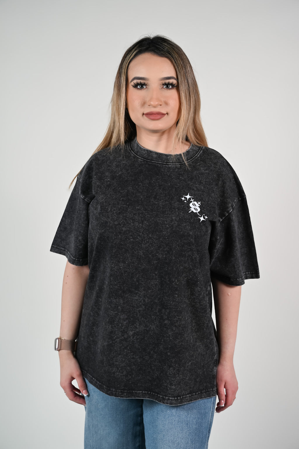 Woman wearing a black t-shirt with a small design on a plain background