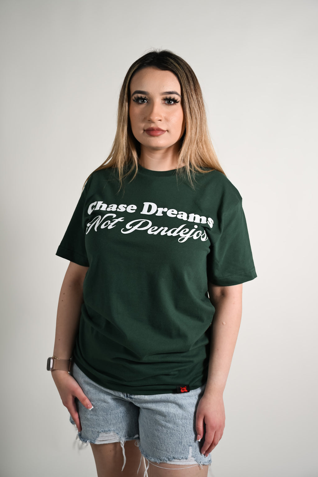 Person wearing a green t-shirt with text on a plain background