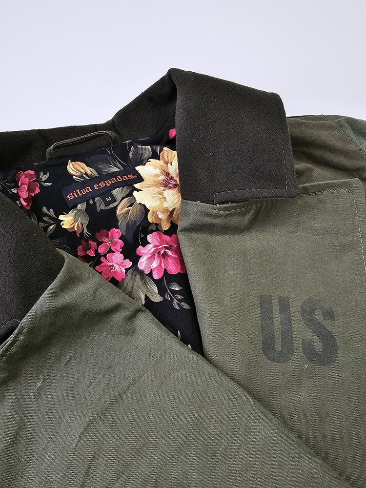 Close-up of cropped canvas jacket collar and lapel showing durable olive military canvas and stitched seam detail
